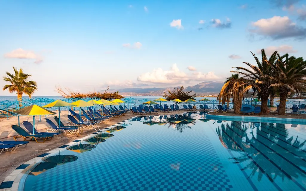 Fin utsikt over svømmebassenget med palmer ved bredden av Middelhavet i Hellas. Kreta