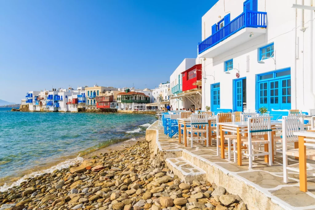 Вид на пляж и здания таверн в районе Маленькая Венеция города Миконос, остров Миконос, Греция