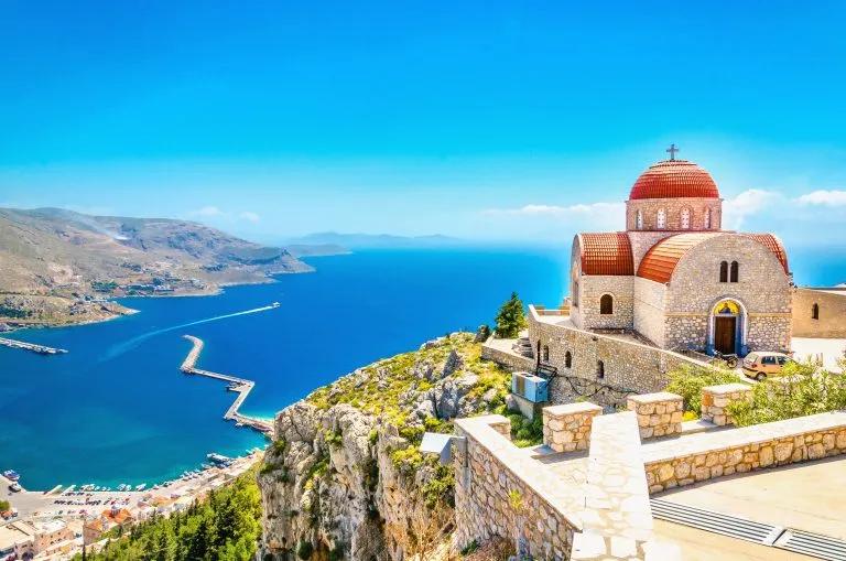 Afsidesliggende kirke med rødt tag på klippe, Grækenland