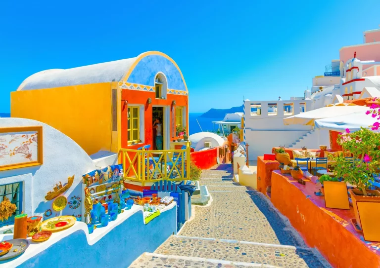 Típica calle estrecha y colorida de Oia, el pueblo más bonito de la isla griega de Santorini.
