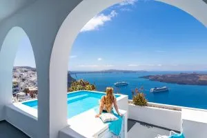 Luxus Sommerurlaub Hintergrund. Junge Frau im Urlaub auf Santorini, Frauen am Swimmingpool mit Blick auf die Caldera Meer von Santorini, Mädchen am Infinity-Pool Santorini Griechenland